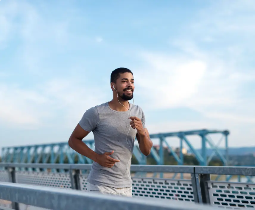 A man running across a bridge with a bridge in the background